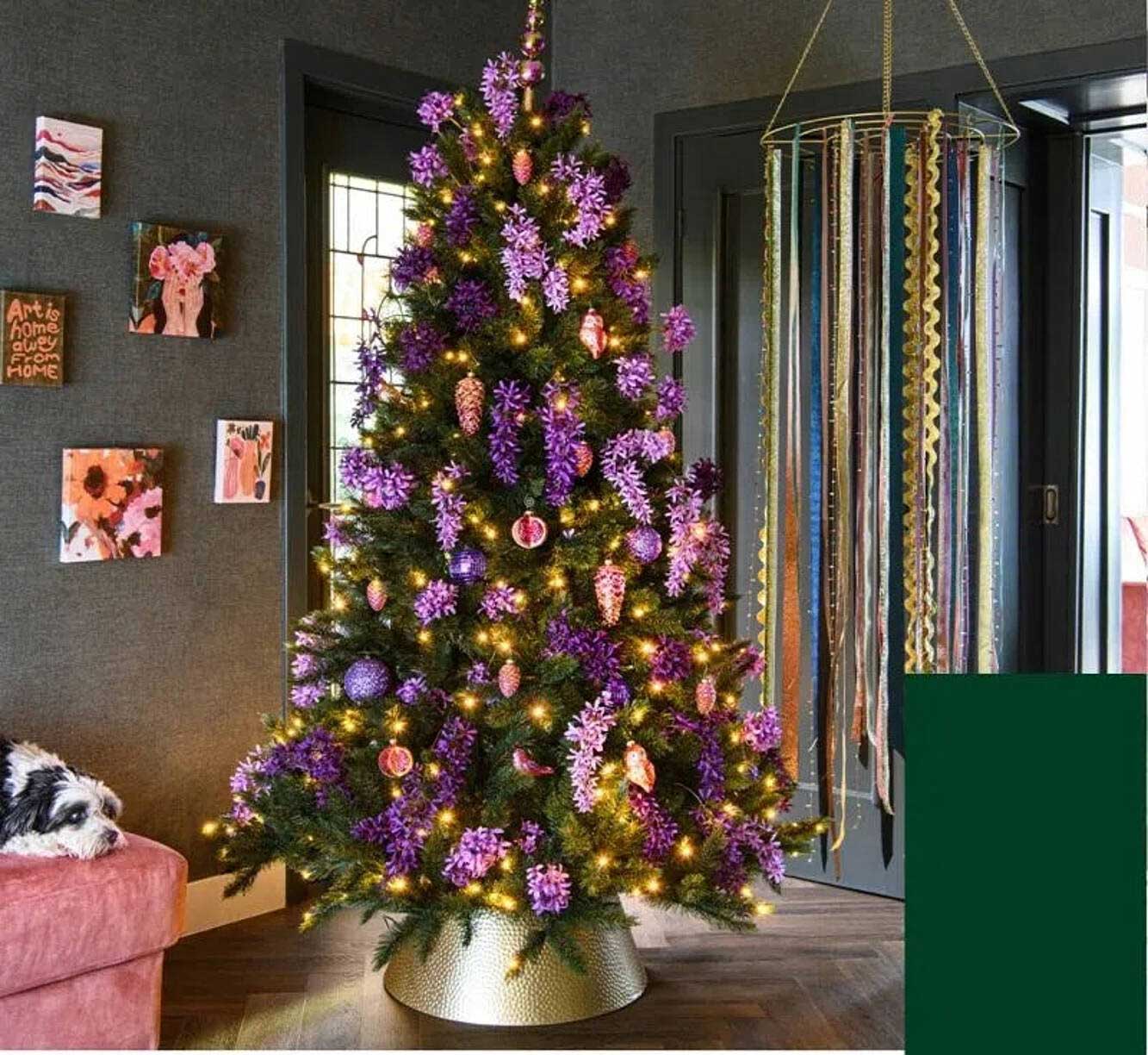 Kerstboom met paarse decoratie en verlichting